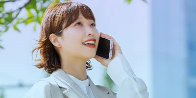 スマートフォンを耳に当てて電話中の女性